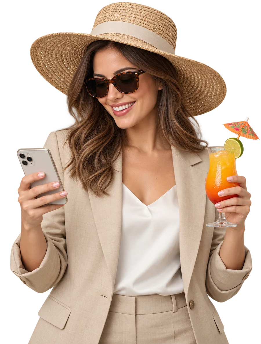 Une femme consulte son téléphone, en vacances, un cocktail à la main.